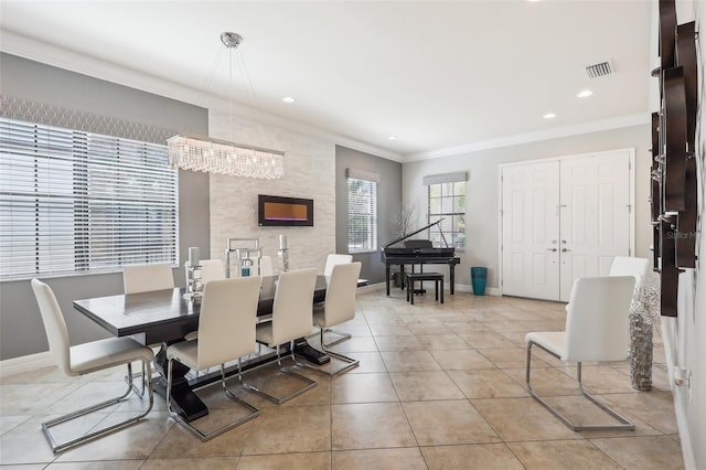 dining area featuring crown molding, light tile patterned floors, and a notable chandelier