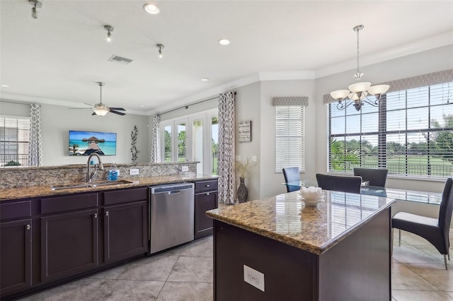 kitchen featuring sink, a center island, light stone counters, decorative light fixtures, and stainless steel dishwasher