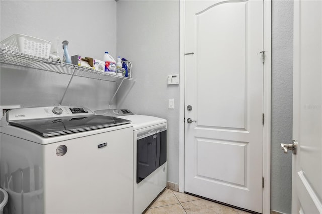 laundry area with light tile patterned flooring and washer and dryer