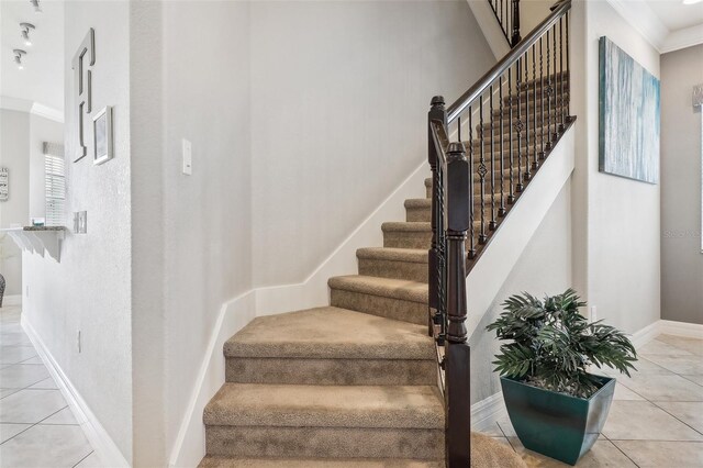 stairway featuring tile patterned flooring and ornamental molding