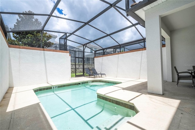 view of pool with glass enclosure and a patio area