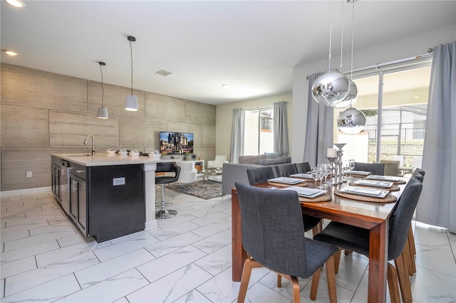 dining area with sink, tile walls, and a wealth of natural light