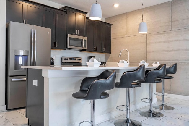 kitchen featuring pendant lighting, a kitchen breakfast bar, and stainless steel appliances