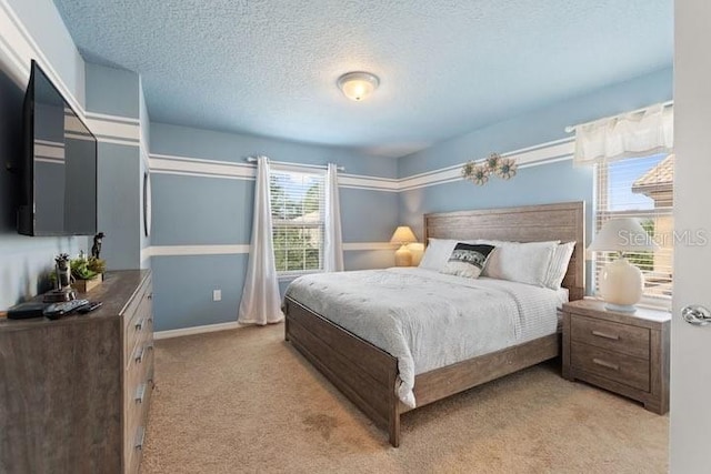 bedroom with a textured ceiling and light colored carpet