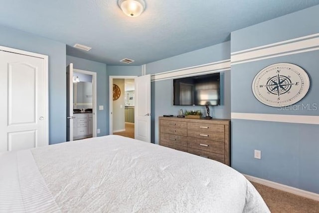 carpeted bedroom featuring ensuite bath