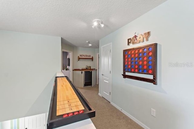 hall featuring carpet flooring and a textured ceiling