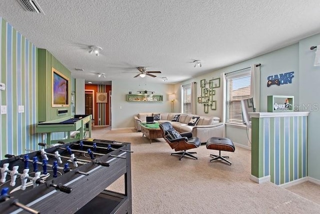 game room featuring ceiling fan, carpet floors, and a textured ceiling