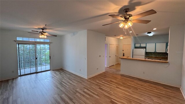 unfurnished living room with ceiling fan and hardwood / wood-style flooring