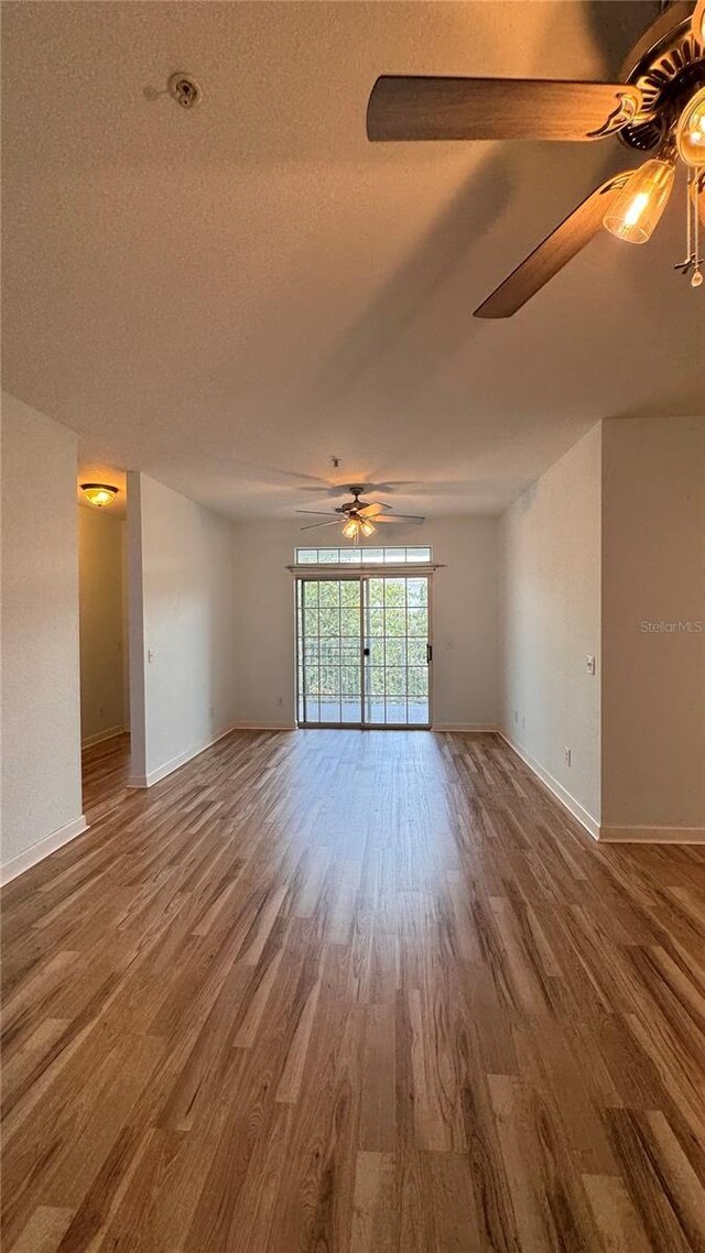 empty room with hardwood / wood-style flooring, ceiling fan, and a textured ceiling