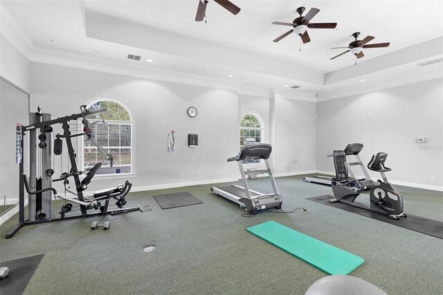 workout room featuring ceiling fan, crown molding, and a raised ceiling