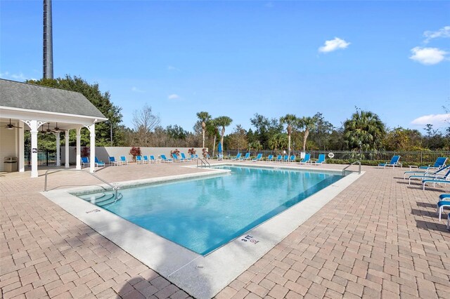 view of pool with a patio and ceiling fan