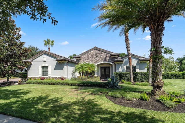 view of front of house featuring a front yard and french doors