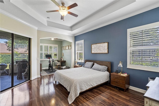 bedroom with ceiling fan, access to exterior, a tray ceiling, and dark hardwood / wood-style flooring