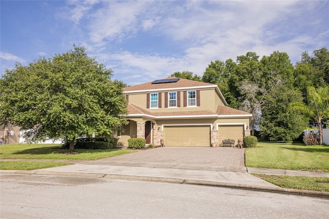 view of front of house with a garage, a front yard, and solar panels