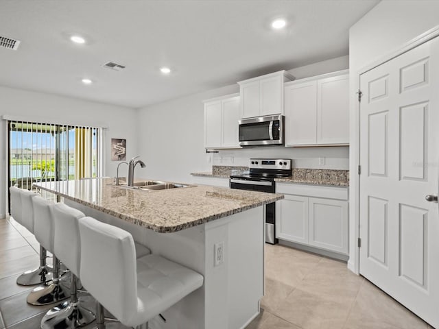 kitchen with white cabinets, an island with sink, and appliances with stainless steel finishes