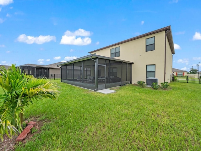 back of house featuring a sunroom, a yard, and central AC