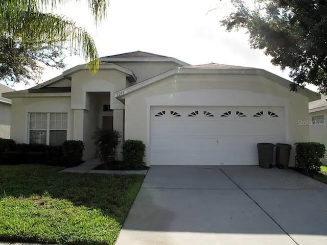 ranch-style house featuring a garage, driveway, and stucco siding