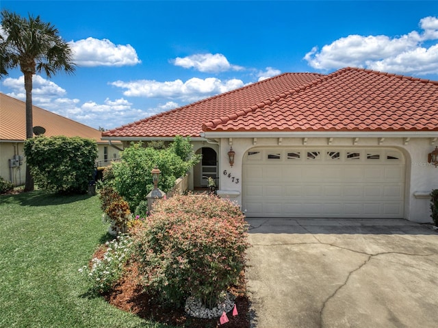 mediterranean / spanish-style home featuring a front lawn and a garage