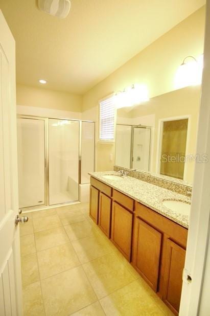 bathroom with tile patterned flooring, vanity, and an enclosed shower