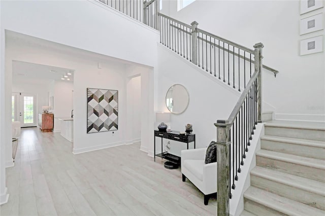 staircase featuring a high ceiling and hardwood / wood-style flooring