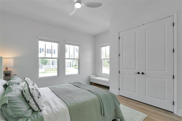 bedroom featuring ceiling fan, a closet, and light wood-type flooring