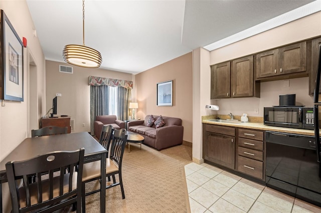 kitchen featuring dark brown cabinets, light tile flooring, pendant lighting, black appliances, and sink