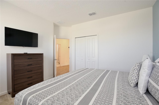 bedroom featuring carpet flooring, a textured ceiling, and a closet