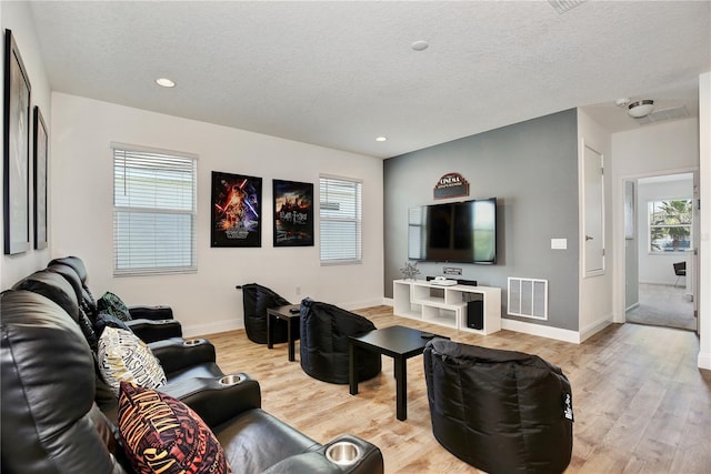 living room featuring light hardwood / wood-style floors and a textured ceiling