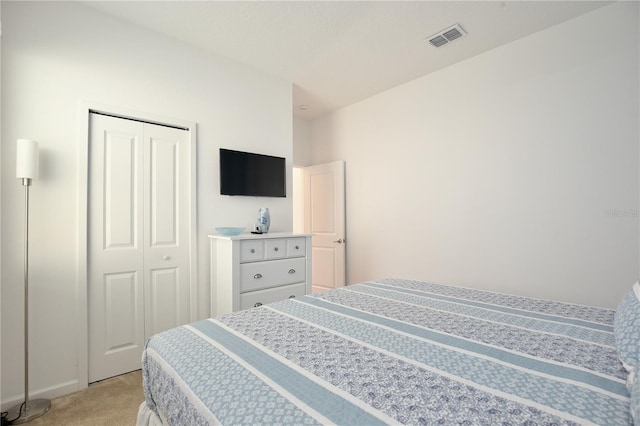 bedroom with light carpet and a closet