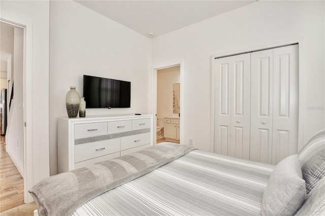 bedroom with connected bathroom, a closet, and light hardwood / wood-style flooring