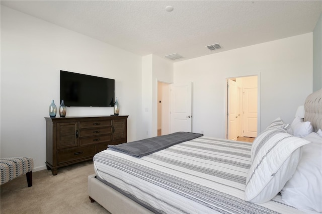 carpeted bedroom with a textured ceiling and ensuite bathroom