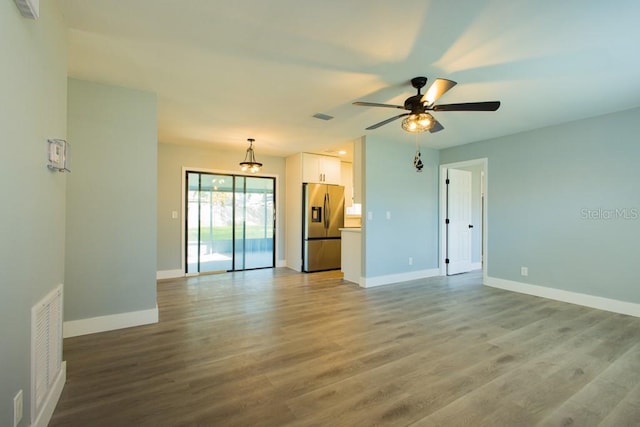 4230 Ponds Dr, Cocoa, FL 32927 - unfurnished living room with baseboards, ceiling fan, and wood finished floors