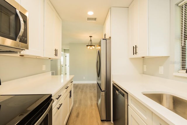 4230 Ponds Dr, Cocoa, FL 32927 - kitchen featuring appliances with stainless steel finishes, white cabinetry, light wood finished floors, light countertops, and recessed lighting
