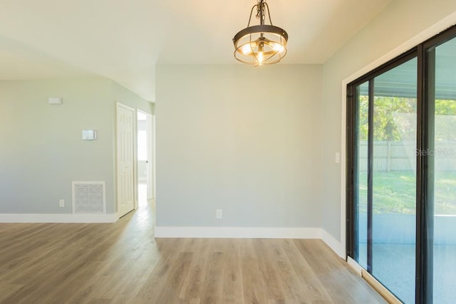 4230 Ponds Dr, Cocoa, FL 32927 - empty room with light wood finished floors, baseboards, and a chandelier