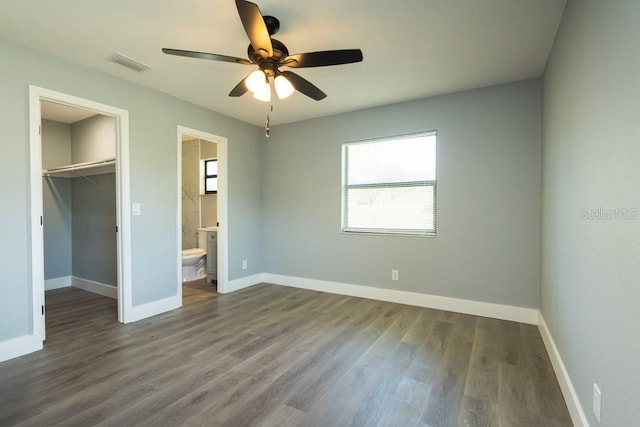 4230 Ponds Dr, Cocoa, FL 32927 - unfurnished bedroom with multiple windows, a walk in closet, and wood finished floors