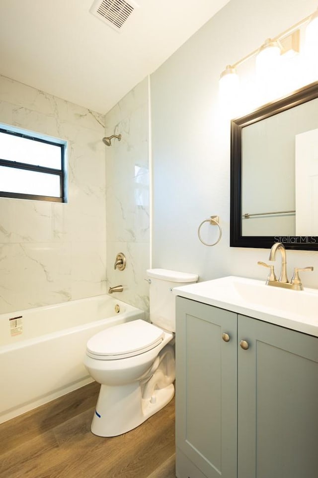 4230 Ponds Dr, Cocoa, FL 32927 - bathroom featuring wood finished floors, toilet, vanity, and shower / tub combination