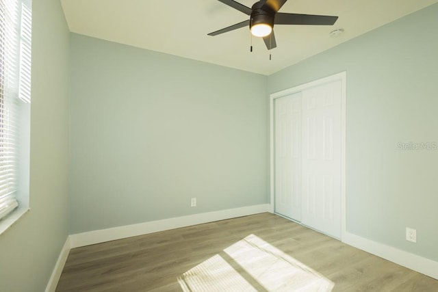 4230 Ponds Dr, Cocoa, FL 32927 - unfurnished bedroom with baseboards, wood finished floors, a closet, and ceiling fan