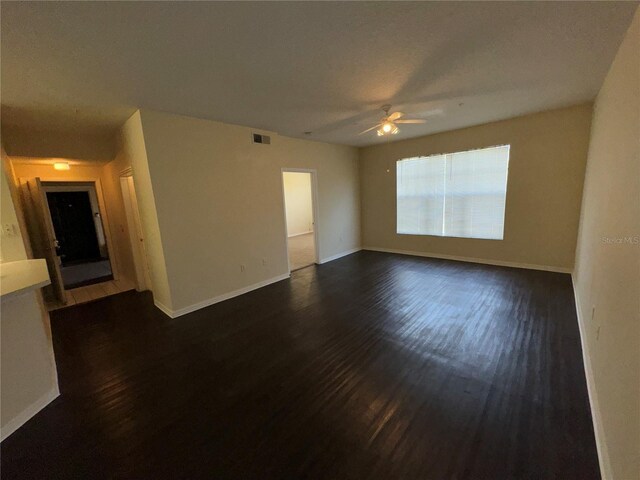 unfurnished room featuring ceiling fan and dark wood-type flooring