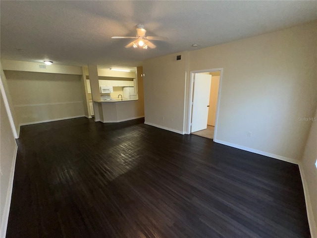 unfurnished living room featuring a textured ceiling, ceiling fan, dark hardwood / wood-style flooring, and sink