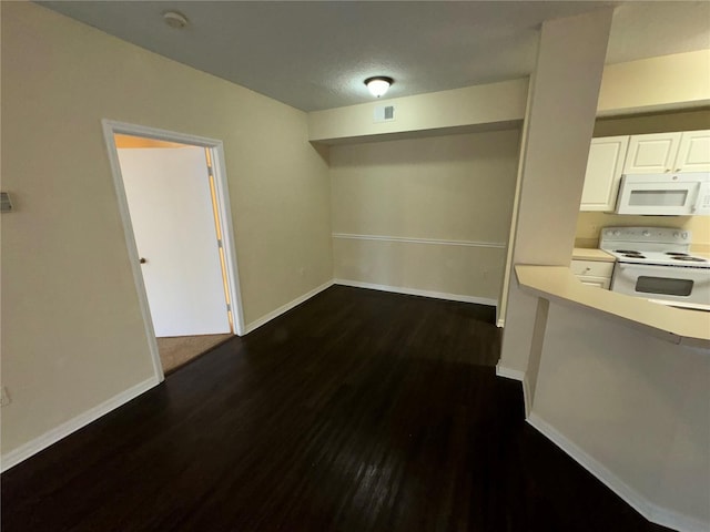 unfurnished dining area with dark hardwood / wood-style flooring and a textured ceiling