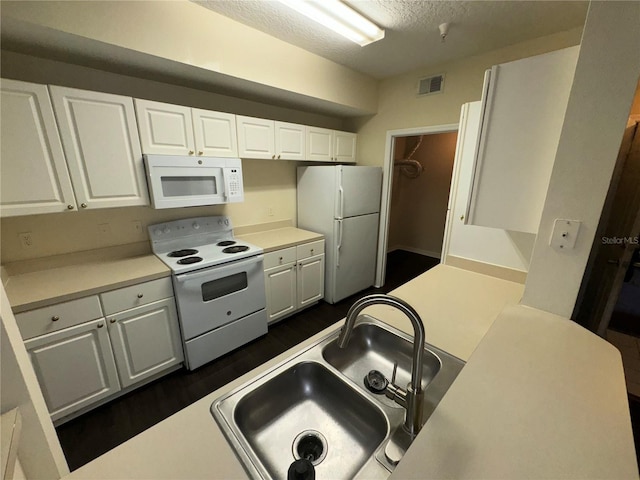 kitchen featuring a textured ceiling, white cabinetry, white appliances, and sink