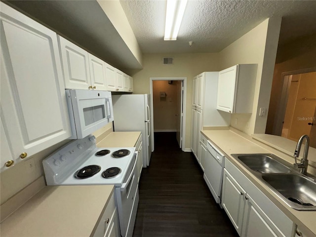 kitchen featuring white appliances, dark wood-type flooring, white cabinets, sink, and a textured ceiling