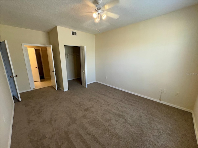 unfurnished bedroom with carpet flooring, ceiling fan, a closet, and a textured ceiling