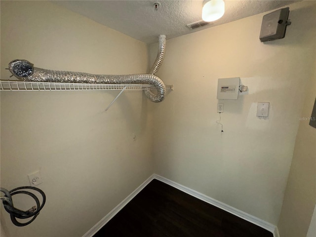 laundry area with hookup for an electric dryer and a textured ceiling