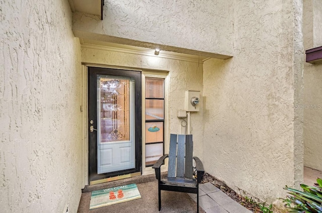 view of exterior entry with stucco siding