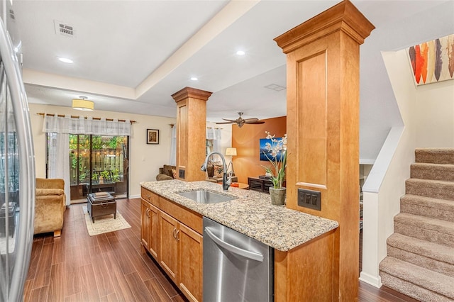 kitchen with stainless steel appliances, a sink, visible vents, open floor plan, and decorative columns