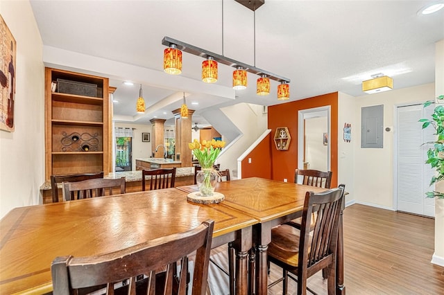 dining room with electric panel, baseboards, ceiling fan, wood finished floors, and recessed lighting