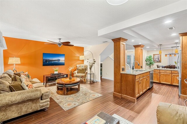 living area featuring decorative columns, visible vents, a ceiling fan, wood finished floors, and recessed lighting