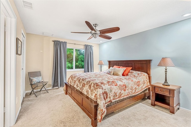 bedroom featuring ceiling fan, light colored carpet, visible vents, and baseboards