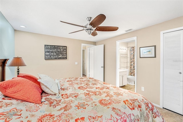 bedroom with light carpet, visible vents, baseboards, ensuite bath, and ceiling fan